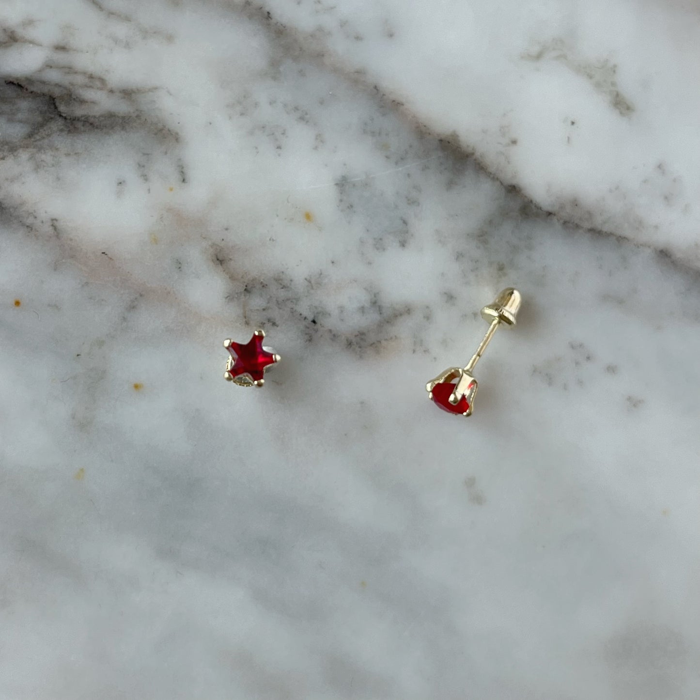 Aretes en oro amarillo 14K con estrella de circonita roja con tope rosca