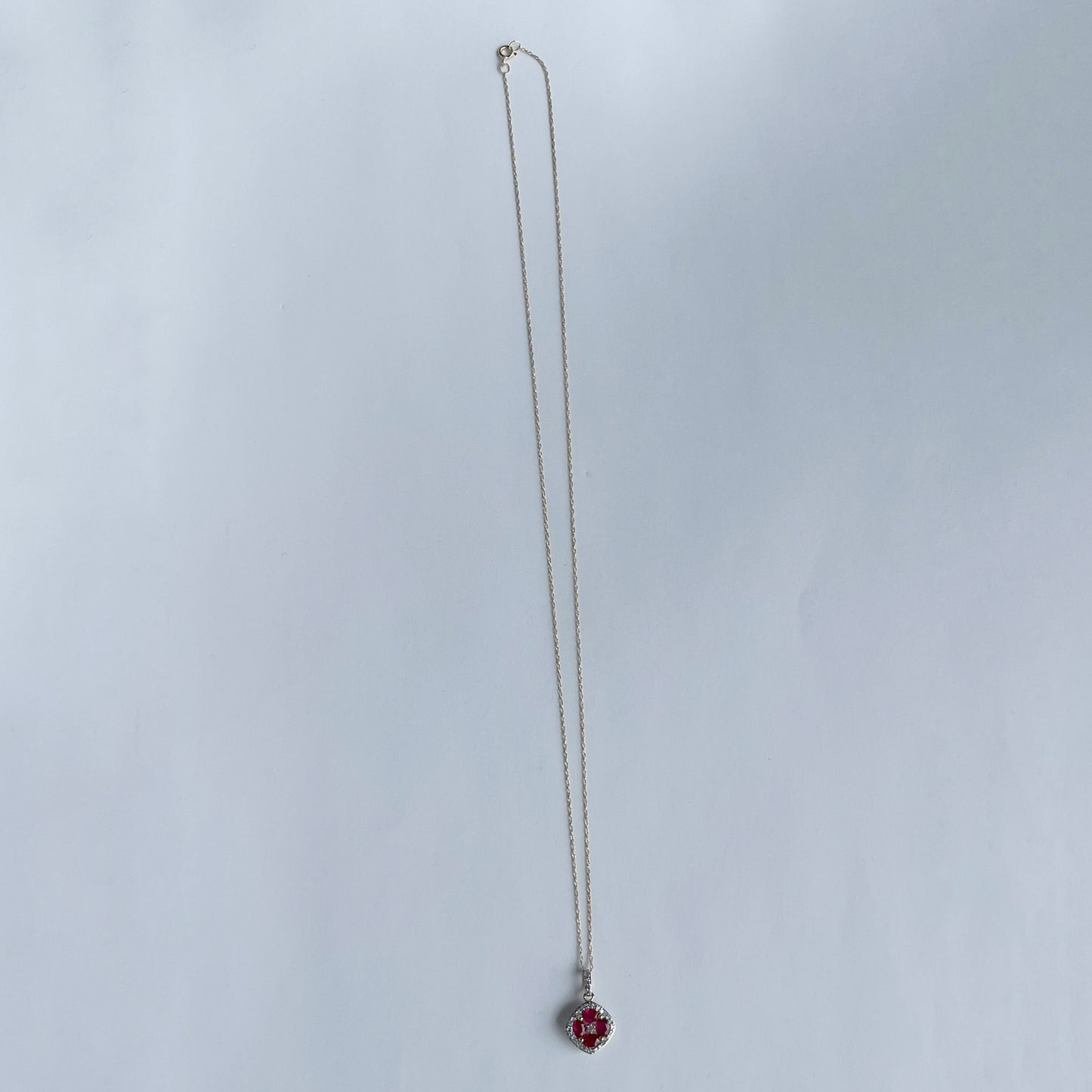 Collar en oro amarillo 14k con dije de rubíes en forma de flor y borde de diamantes 0.15ctw