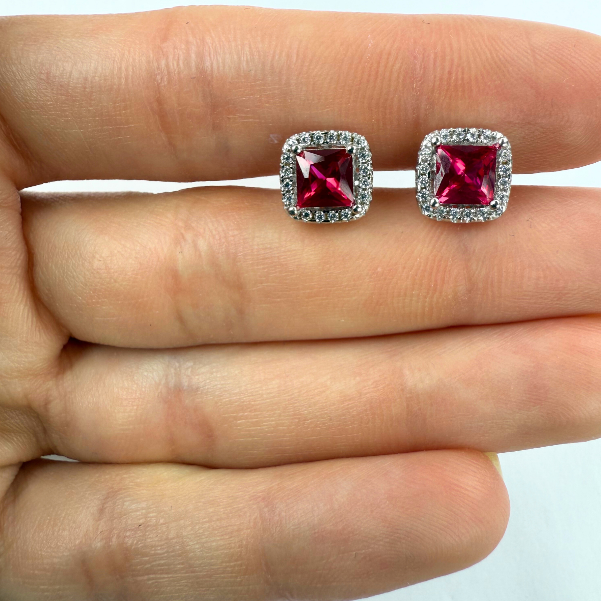 Arete con circón rojo corte princesa y halo de zafiro blancos en plata