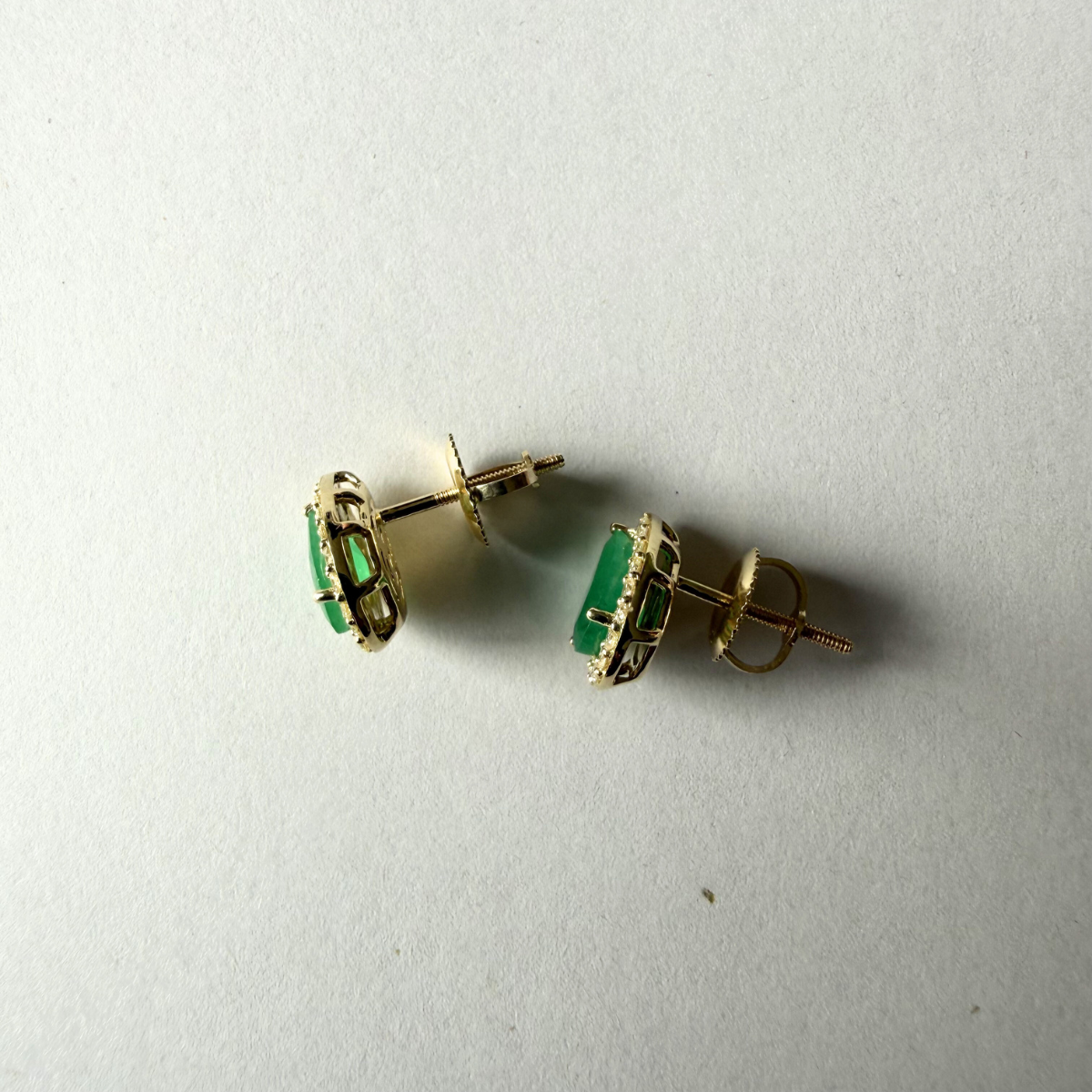 Aretes en oro amarillo 10K con esmeralda corte pera y halo de diamantes 0.30ctw