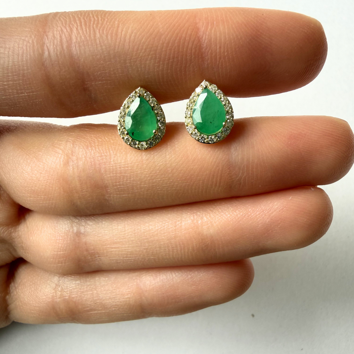 Aretes en oro amarillo 10K con esmeralda corte pera y halo de diamantes 0.30ctw