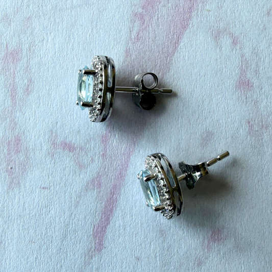 Aretes en oro blanco 14k con aquamarina ovalada y halo de diamantes 0.18ctw