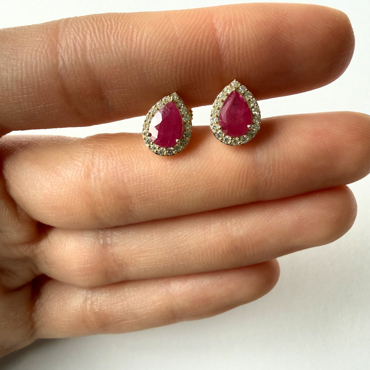 Aretes en oro amarillo 10K con rubí corte pera y halo de diamantes 0.30ctw con broche rosca
