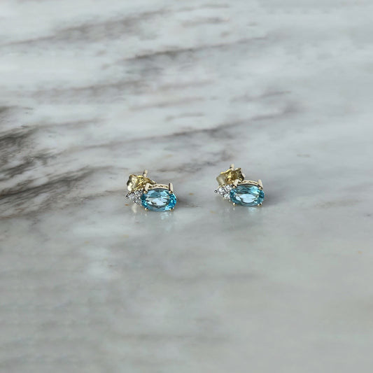 Studs en oro amarillo 10k con topacio azul ovalado y 3 diamantes
