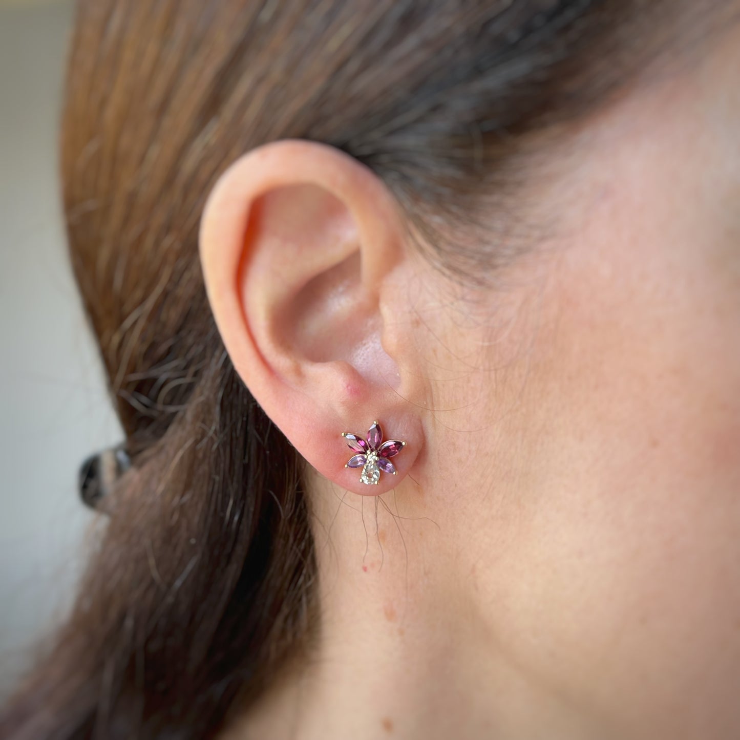 Aretes en oro amarillo 14k con petalos de topacio blanco y granate rhodolite