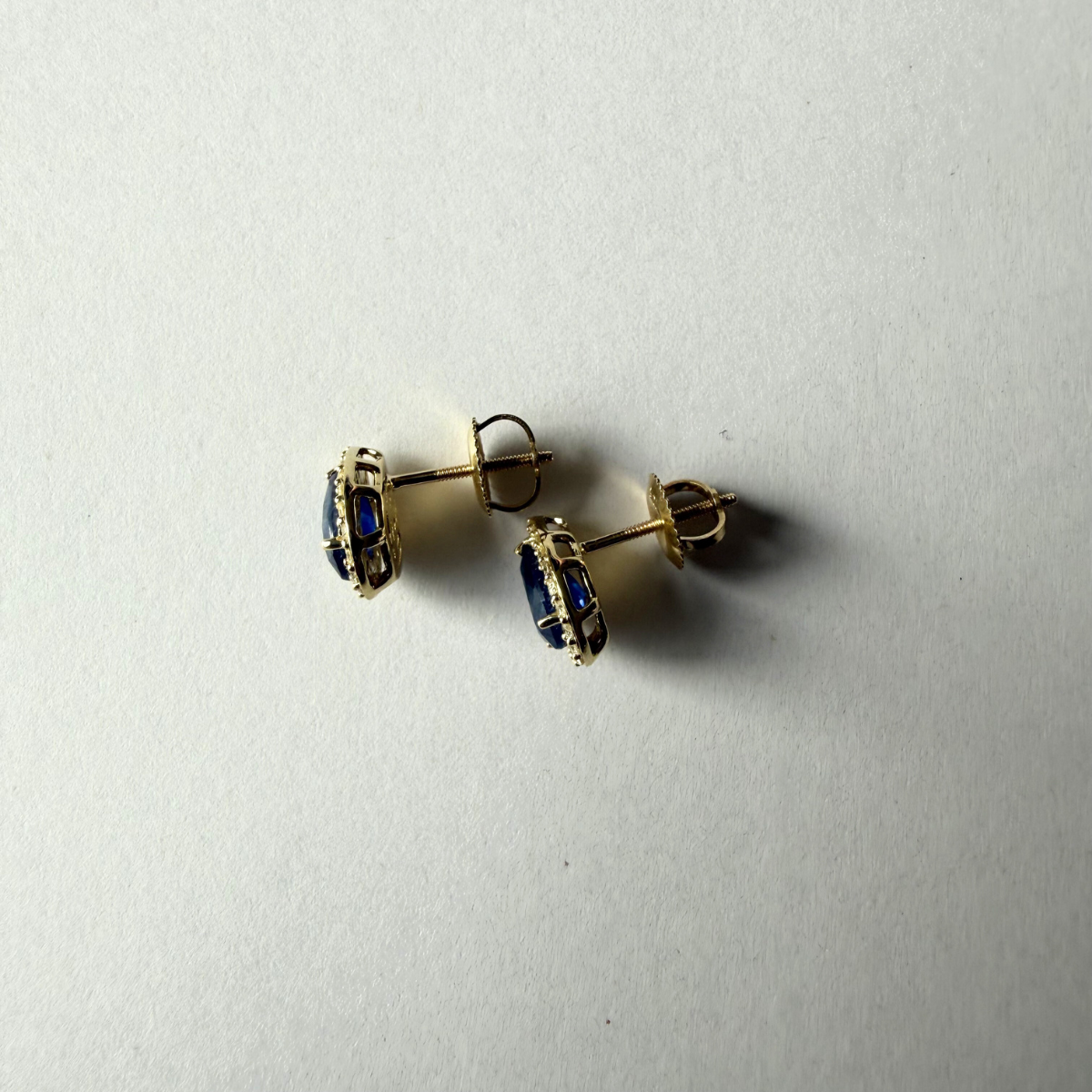 Aretes en oro amarillo 10K con zafiro corte pera y halo de diamantes 0.30ctw con broche rosca