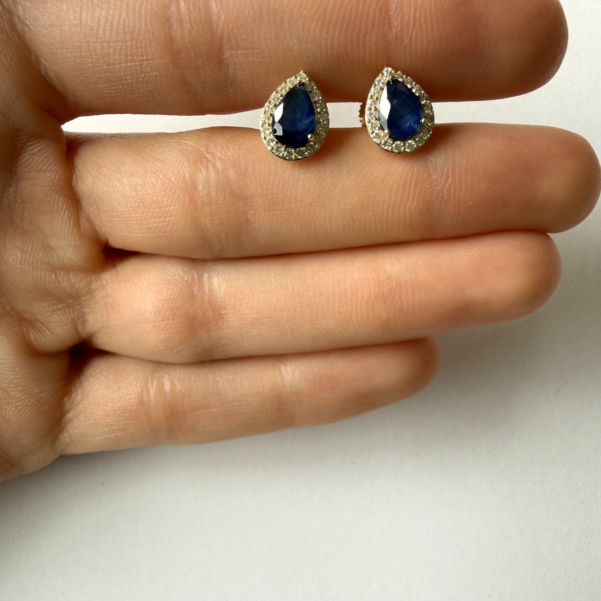 Aretes en oro amarillo 10K con zafiro corte pera y halo de diamantes 0.30ctw con broche rosca