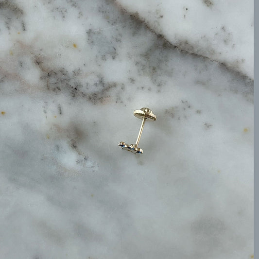 Arete en oro amarillo de 14K con estrella tipo flor con circonita azul en los extremos y estrella calada en el centro con tope rosca