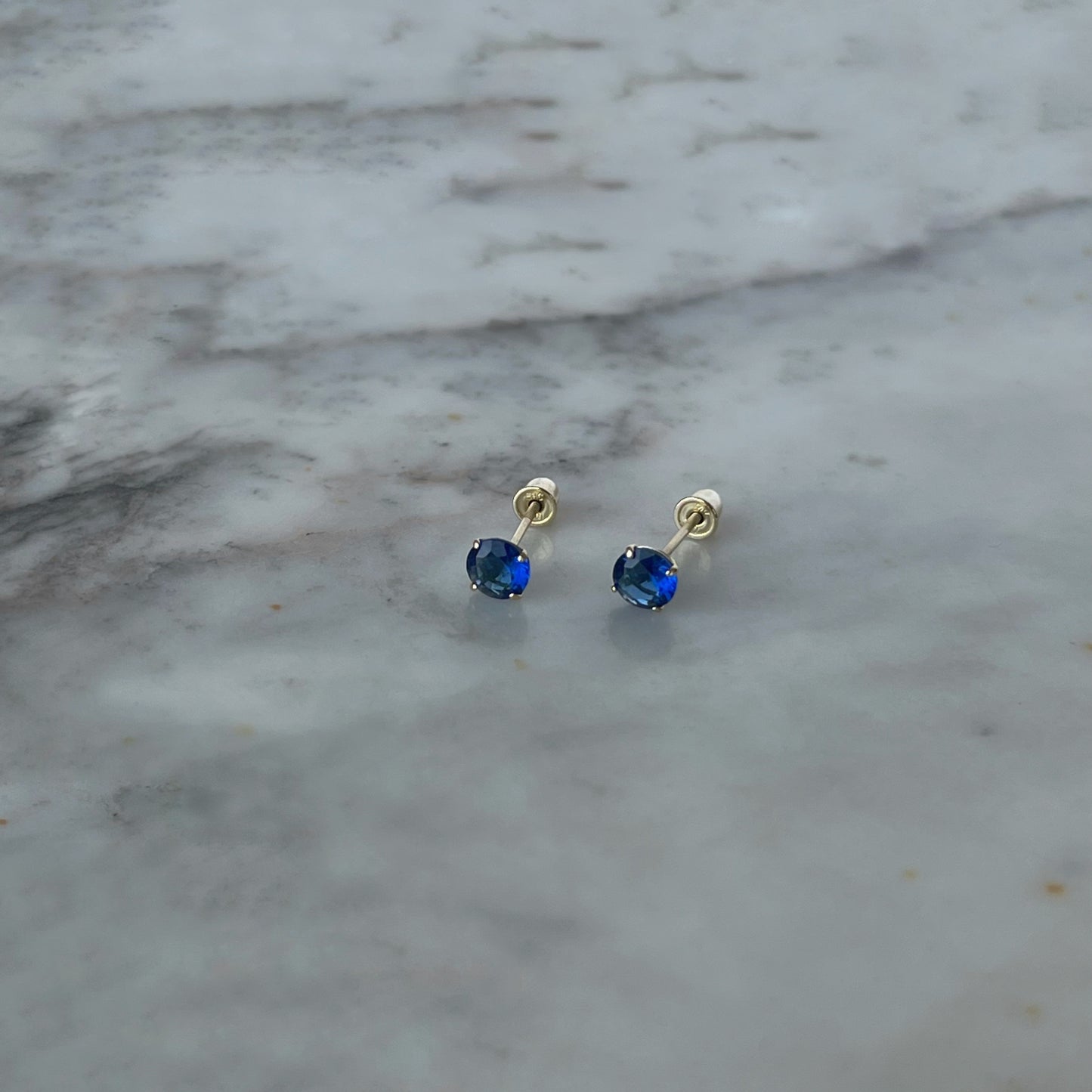 Aretes en oro amarillo 14K con circón azul de 4mm con tope rosca