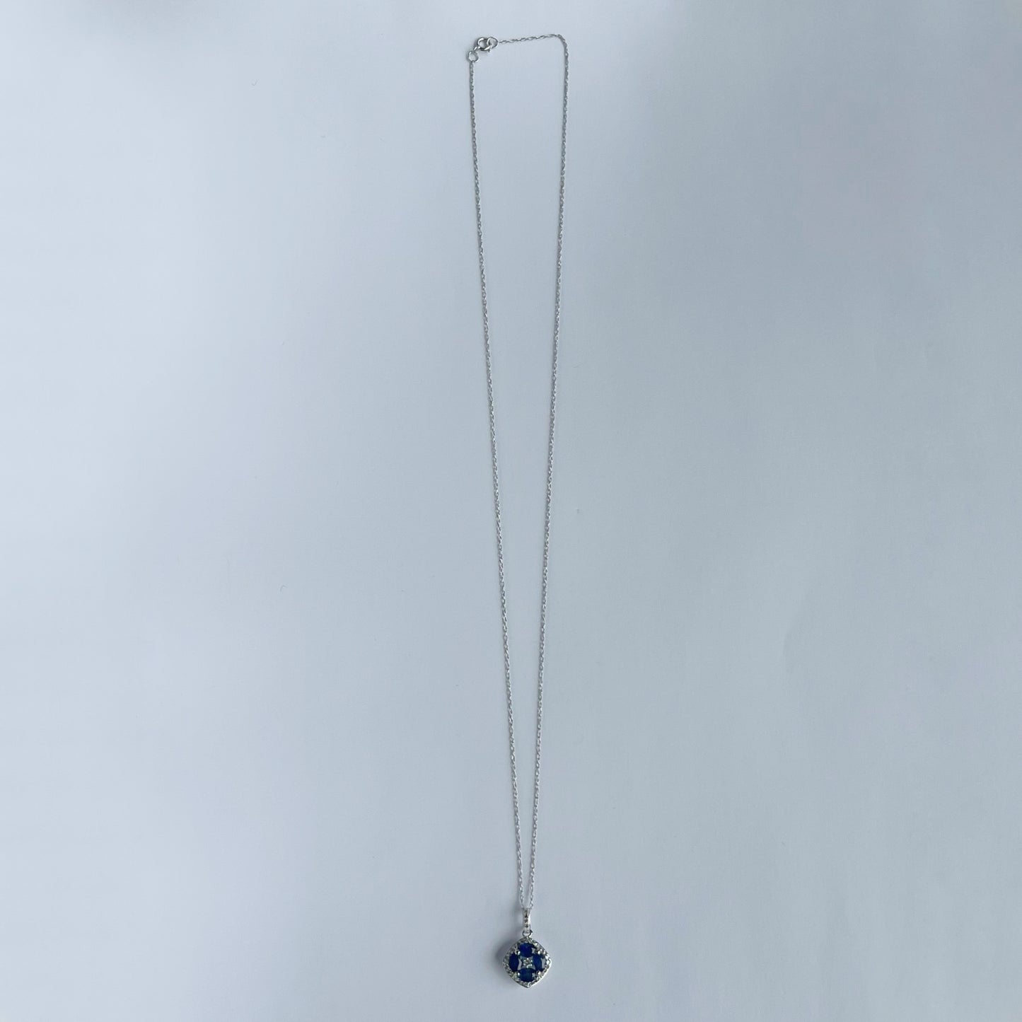 Collar en oro blanco 14k con dije de zafiros en forma de flor y borde de diamantes 0.15ctw