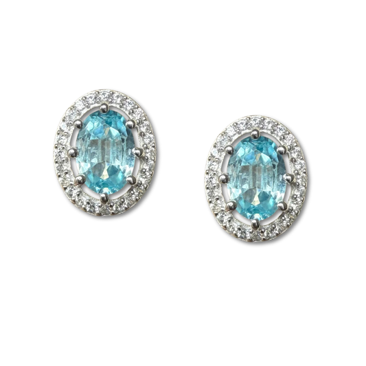 Aretes de plata con topacio azul ovalado y halo de circones
