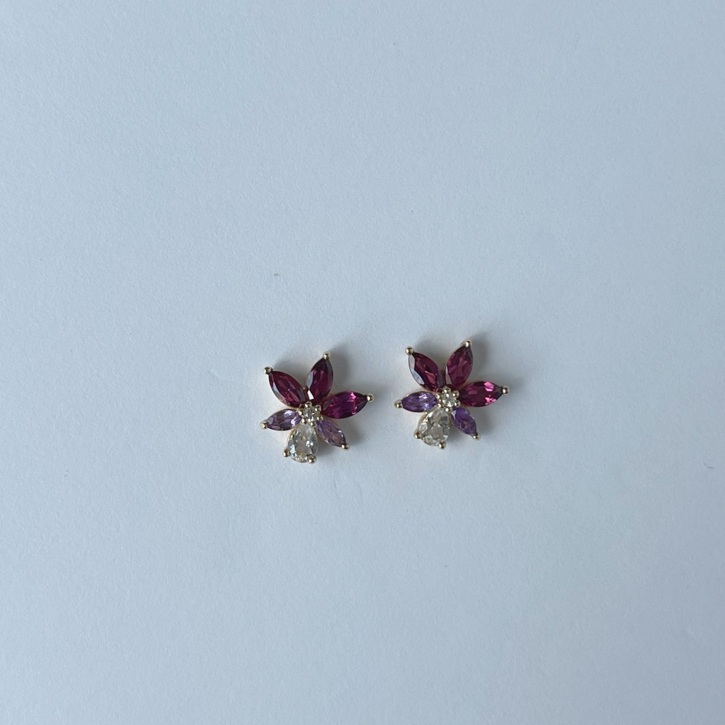 Aretes en oro amarillo 14k con petalos de topacio blanco y granate rhodolite