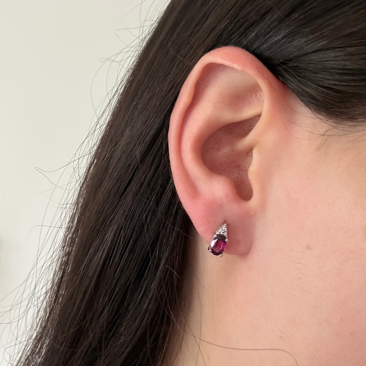 Aretes en oro blanco 10k con granate ovalado y tres diamantes 0.03ctw