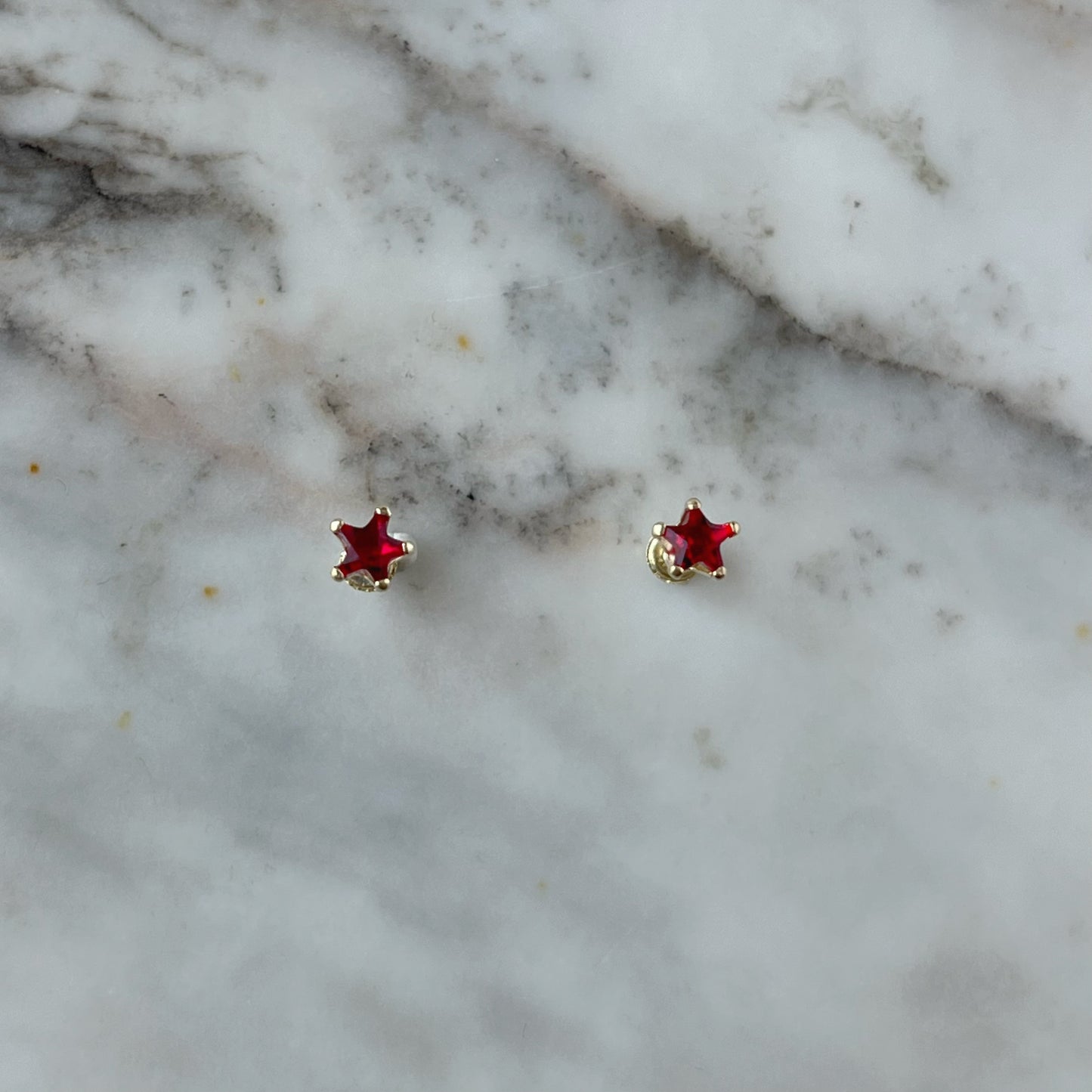 Aretes en oro amarillo 14K con estrella de circonita roja con tope rosca