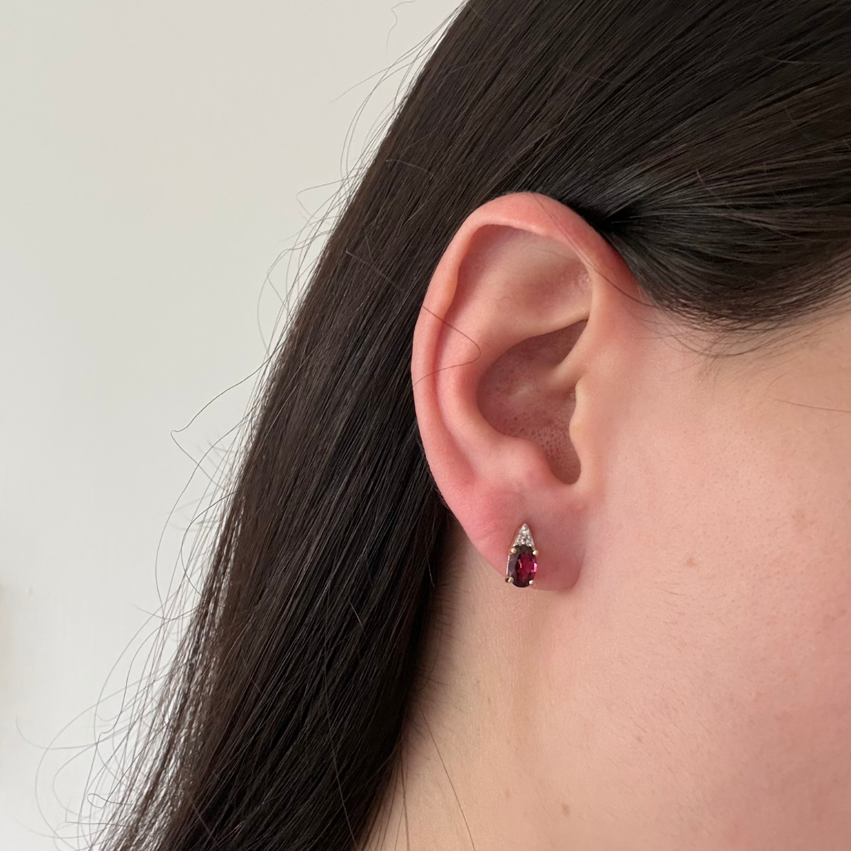 Aretes en oro amarillo 10k con granate ovalado y tres diamantes 0.03ctw