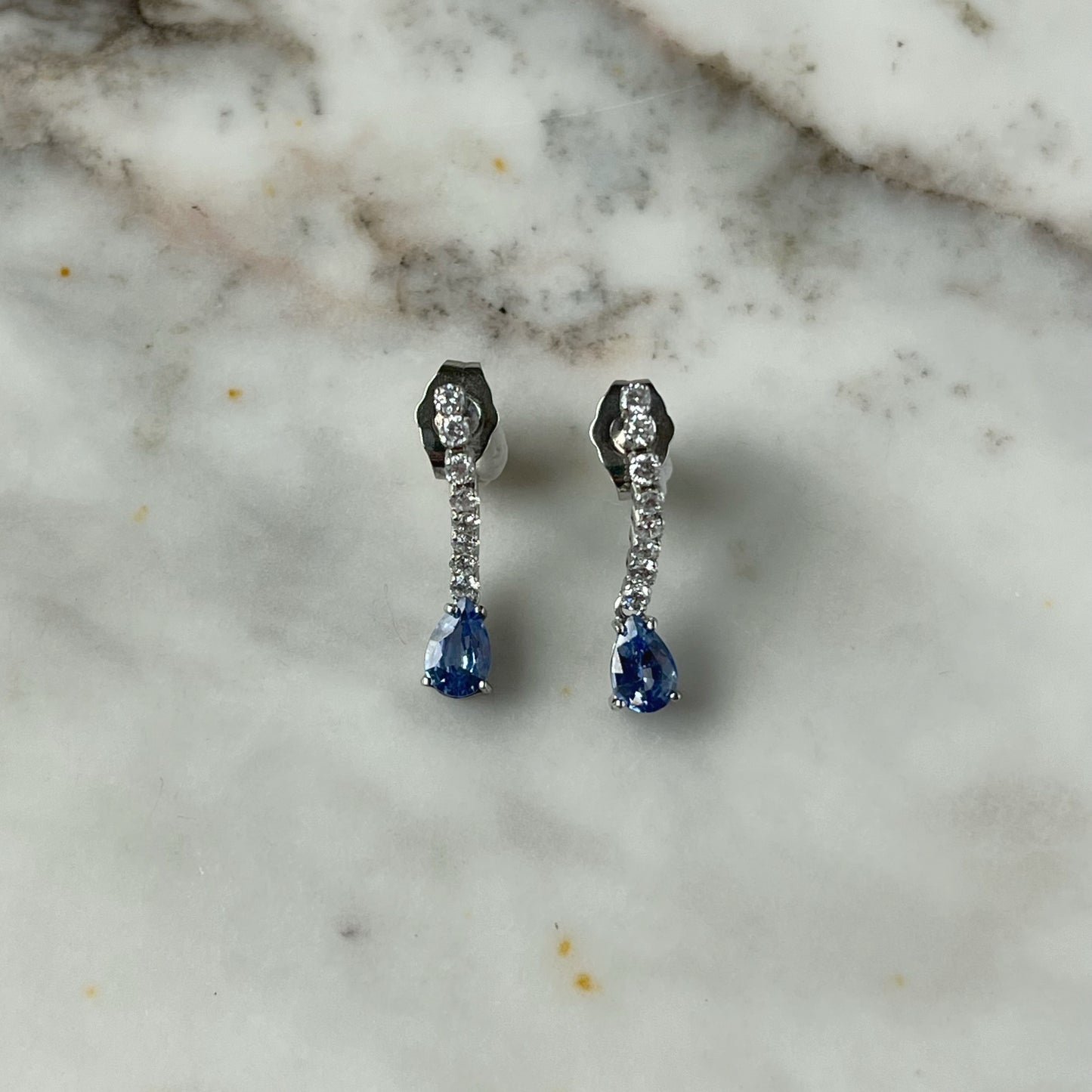 Aretes en oro blanco de 14k con línea de diamantes de laboratorio 0.25ctw y gota de zafiro azul natural