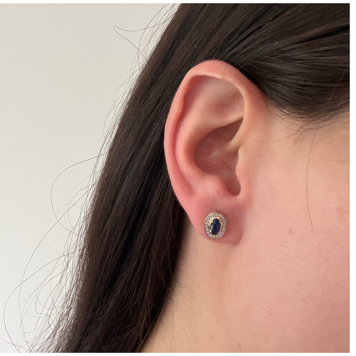 Aretes en oro amarillo 10K con zafiro ovalado y halo de diamantes 0.05ctw