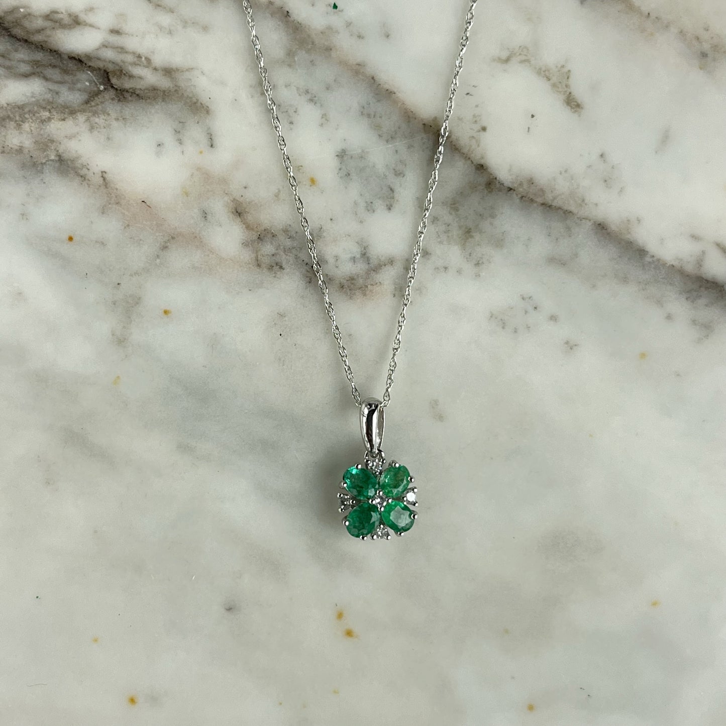 Collar en oro blanco 10k con flor de esmeraldas y diamantes 0.06ct