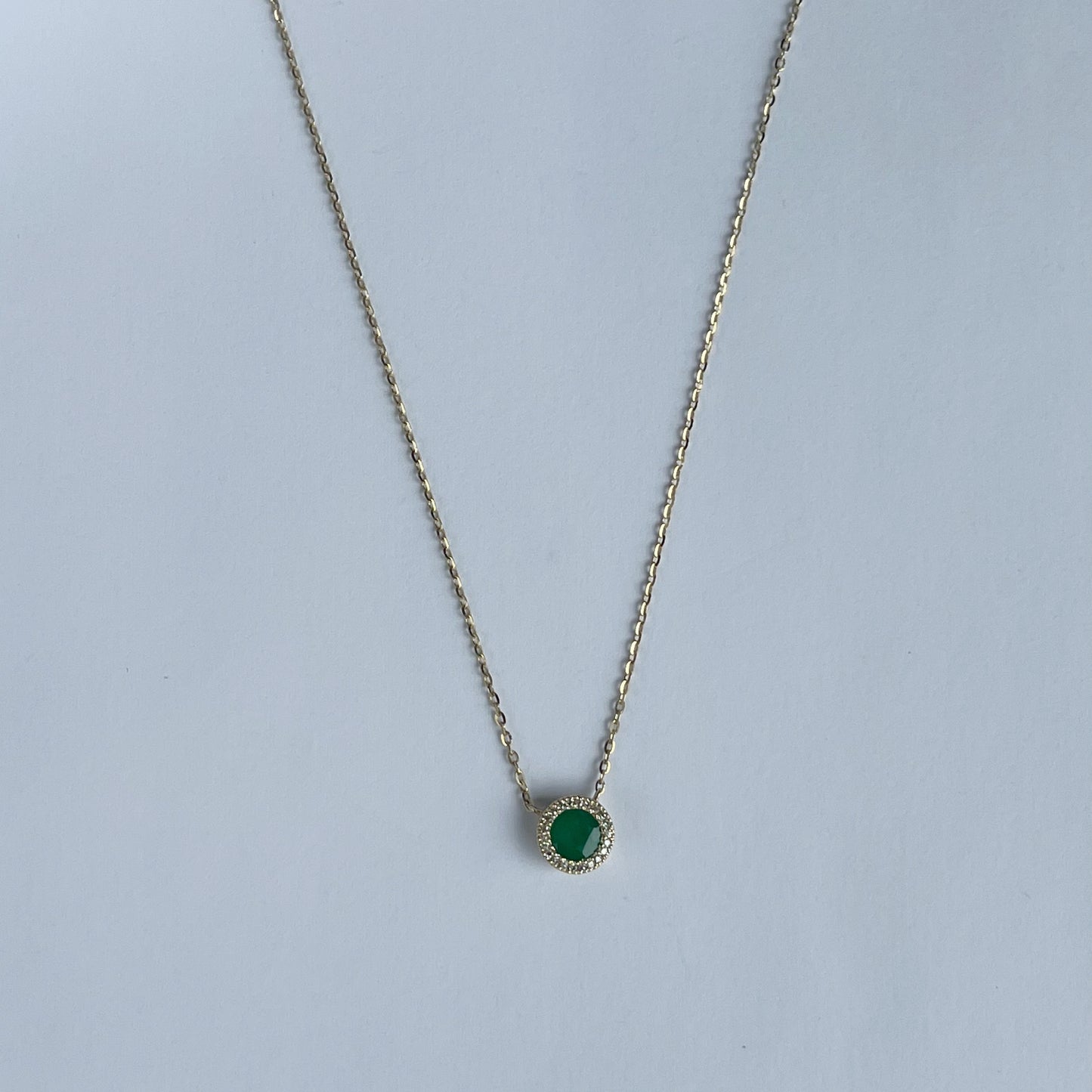 Collar en oro amarillo 14k con esmeralda redonda y halo de diamantes 0.06ctw