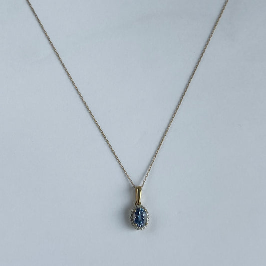 Collar en oro amarillo 10k con dije de tanzanita ovalada y halo de diamantes