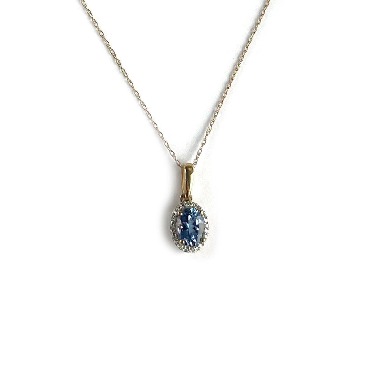 Collar en oro amarillo 10k con dije de tanzanita ovalada y halo de diamantes