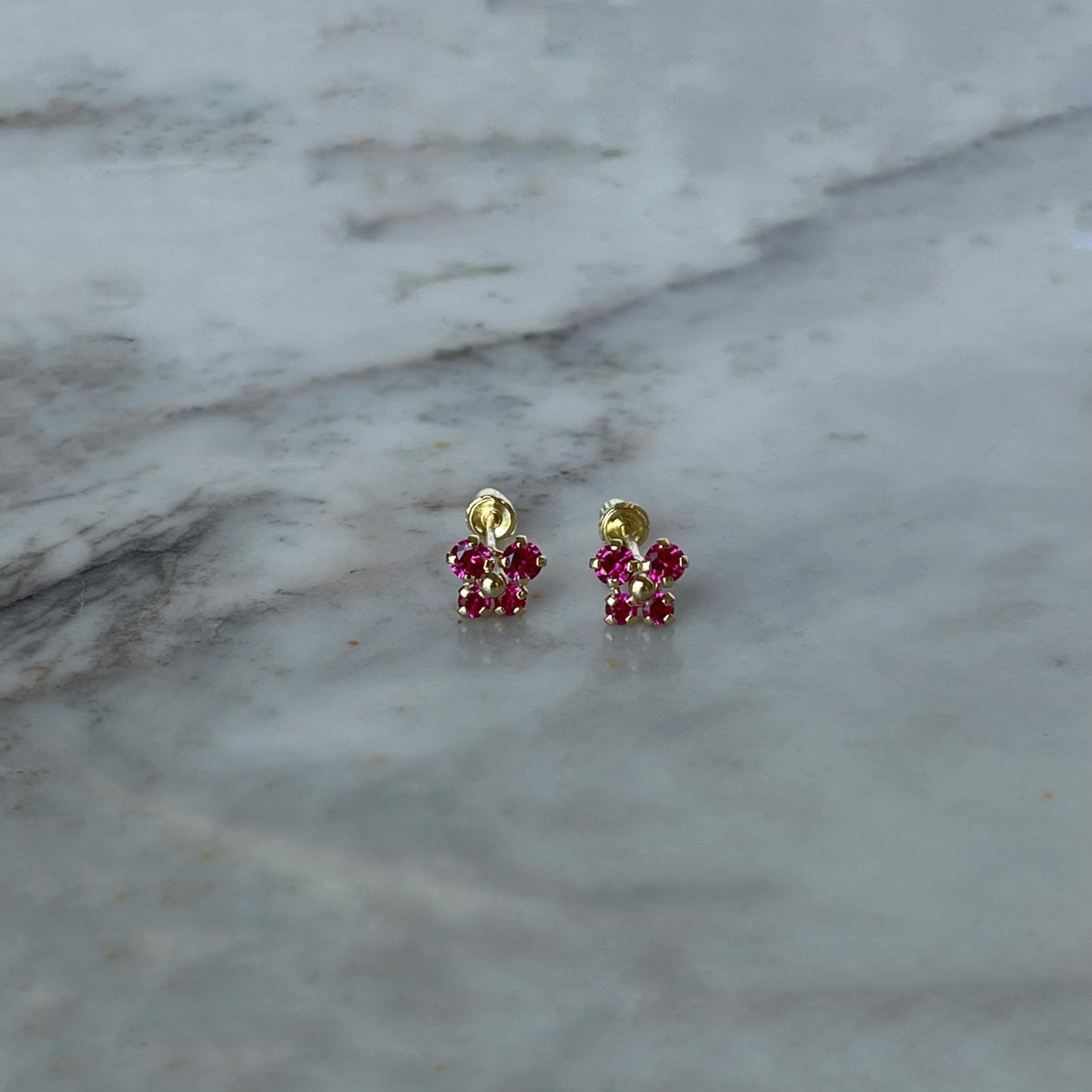 Aretes en oro amarillo 14K con mariposa con circonita fucsia y bolita de oro en el centro con tope rosca