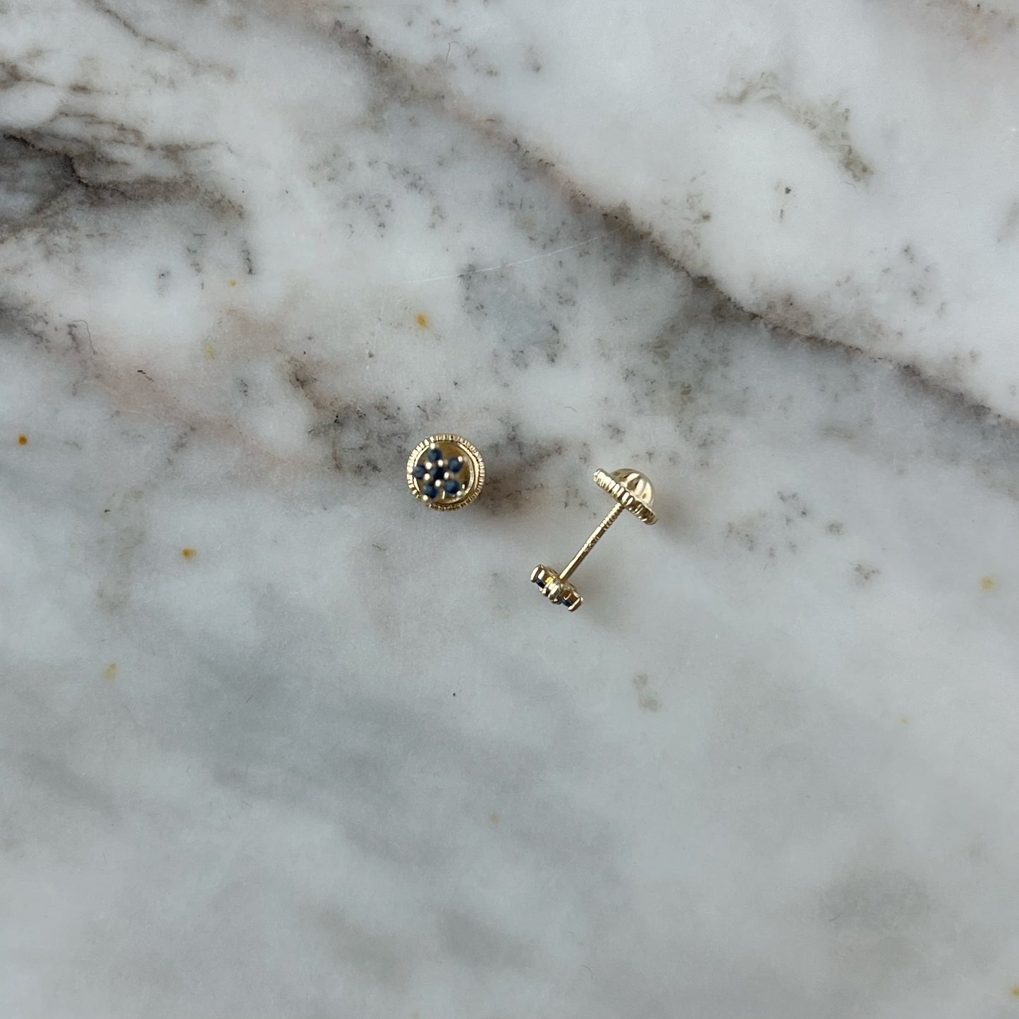 Aretes en oro amarillo de 14K con mini flor de circonitas azules con agarres con tope rosca