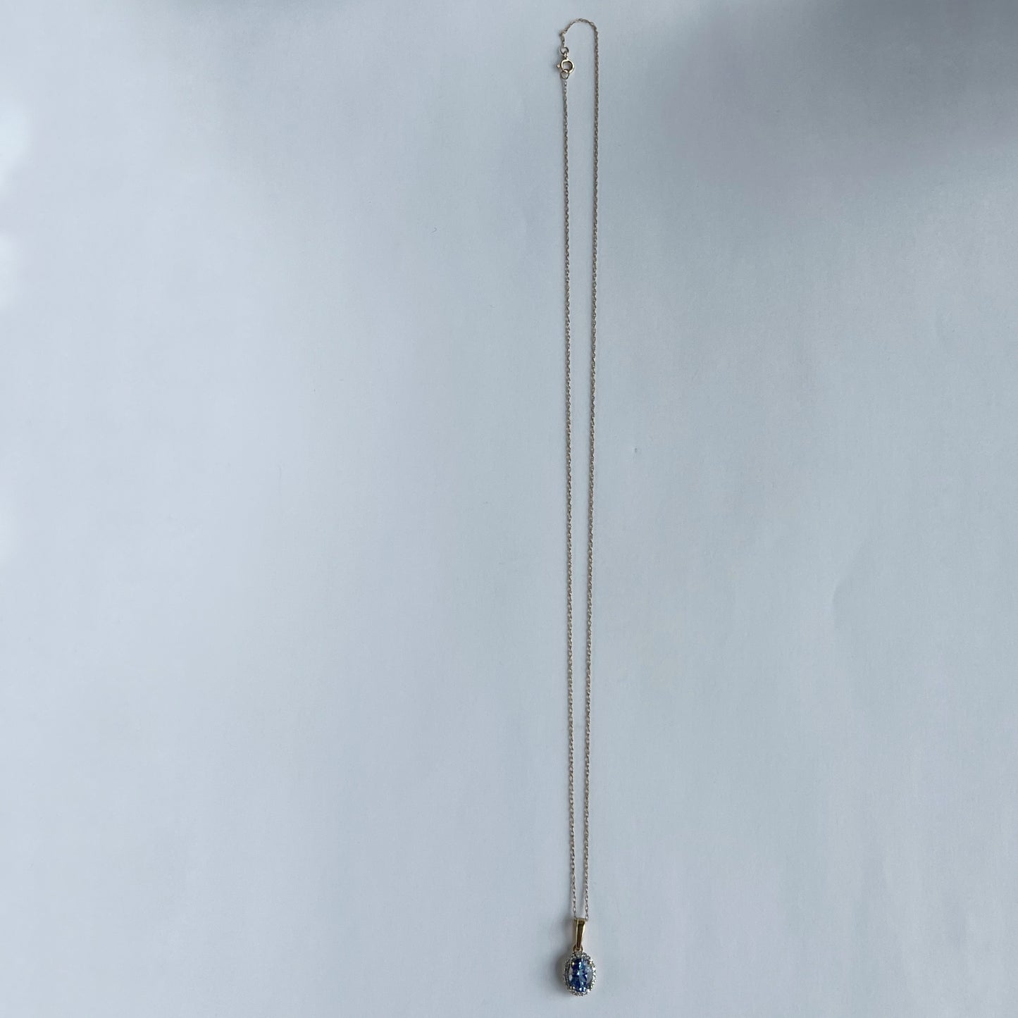 Collar en oro amarillo 10k con dije de tanzanita ovalada y halo de diamantes