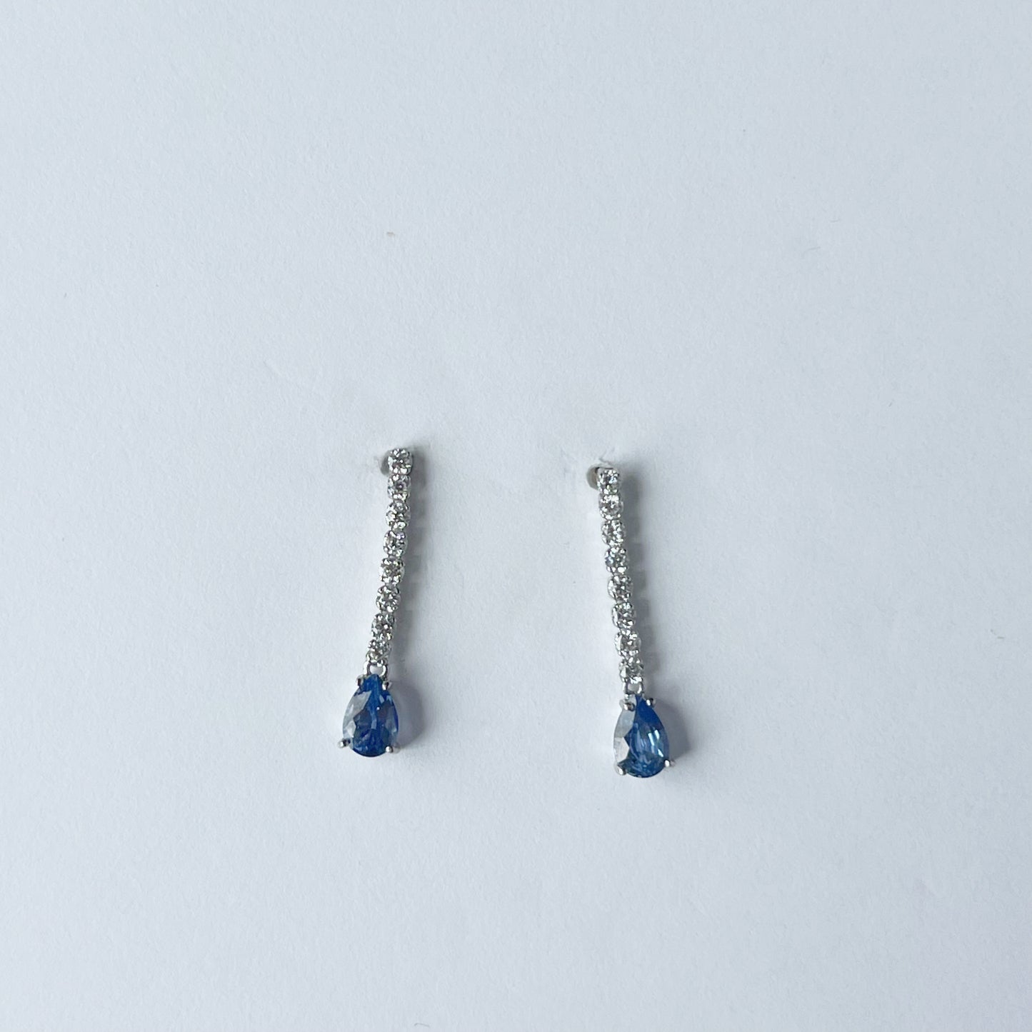 Aretes en oro blanco de 14k con línea de diamantes de laboratorio 0.25ctw y gota de zafiro azul natural