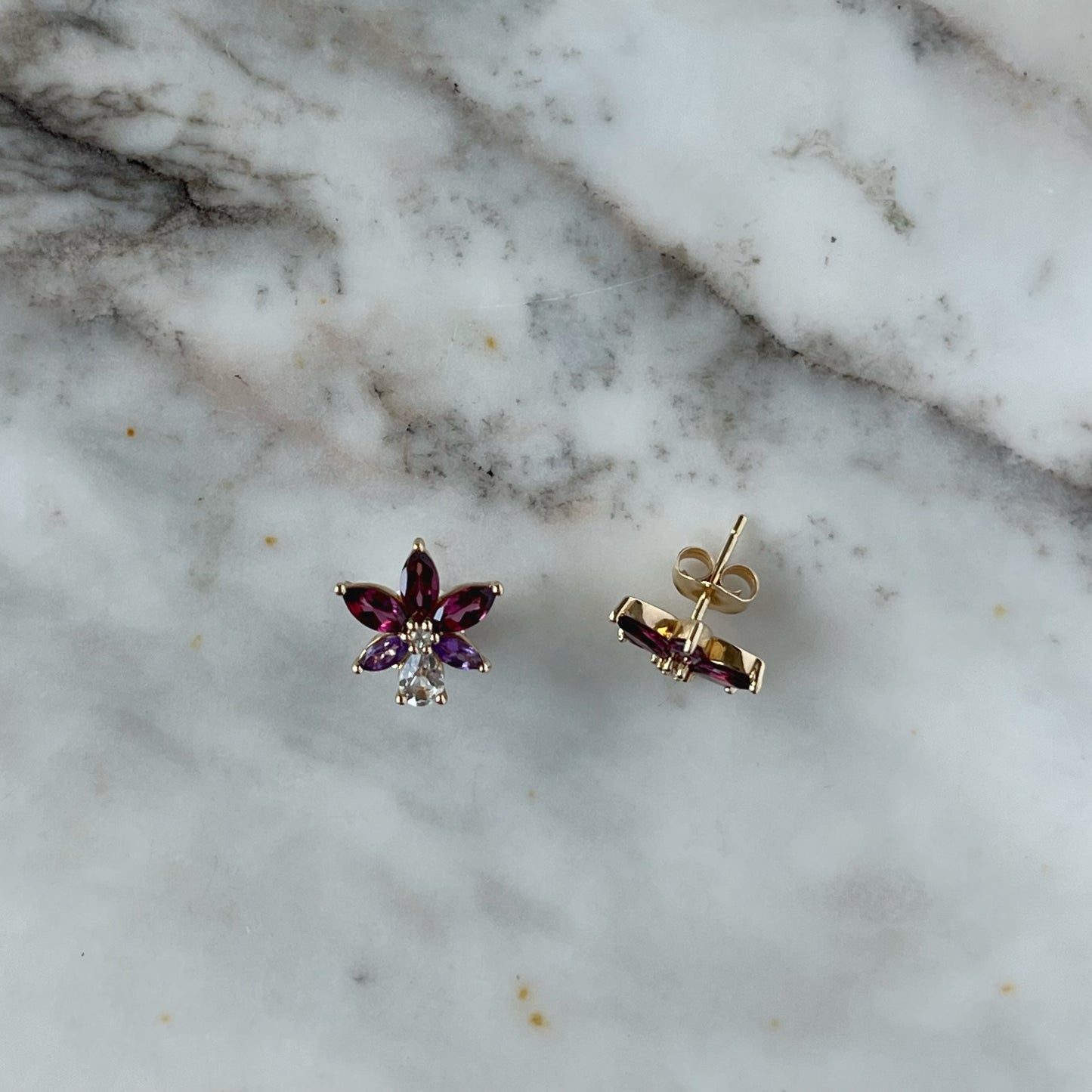 Aretes en oro amarillo 14k con petalos de topacio blanco y granate rhodolite