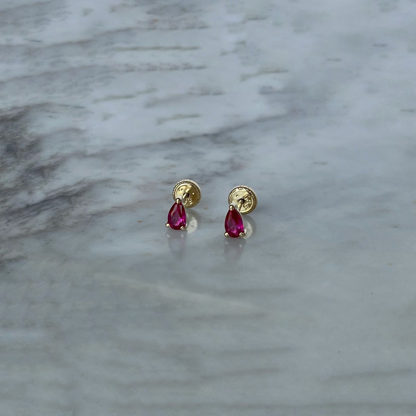 Aretes en oro amarillo 14K en forma de gota con circonita roja con tope rosca