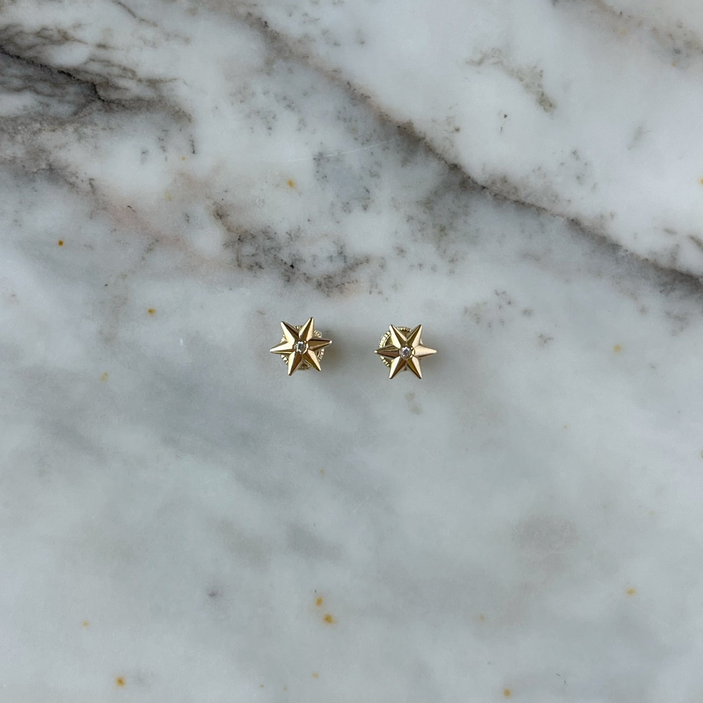 Aretes en oro amarillo 14K con estrella de 6 puntas y circón blanco en el centro con tope rosca