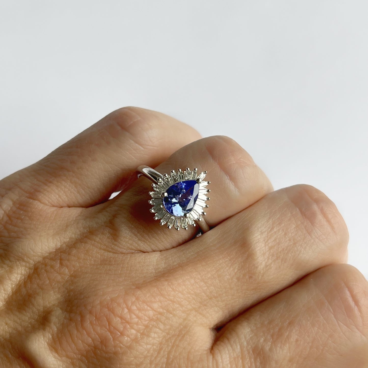 Anillo de oro blanco 10K con tanzanita corte pera y halo de diamantes baguette 0.20ct