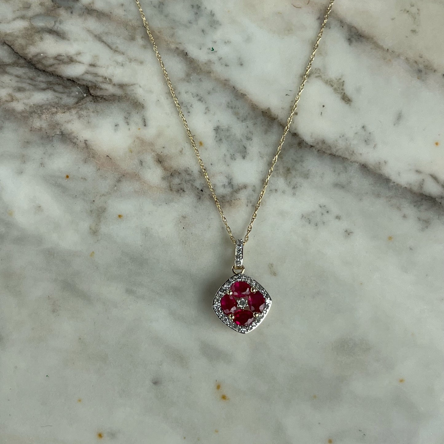 Collar en oro amarillo 14k con dije de rubíes en forma de flor y borde de diamantes 0.15ctw