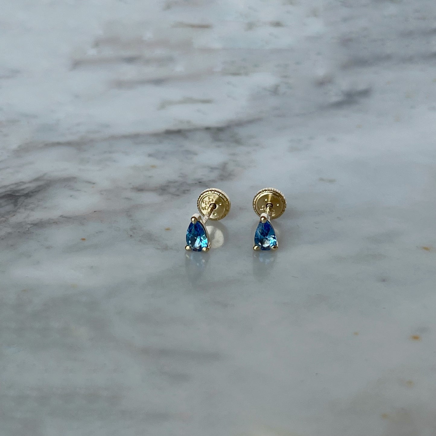 Aretes en oro amarillo 14K en forma de gota con circonita azul con tope rosca