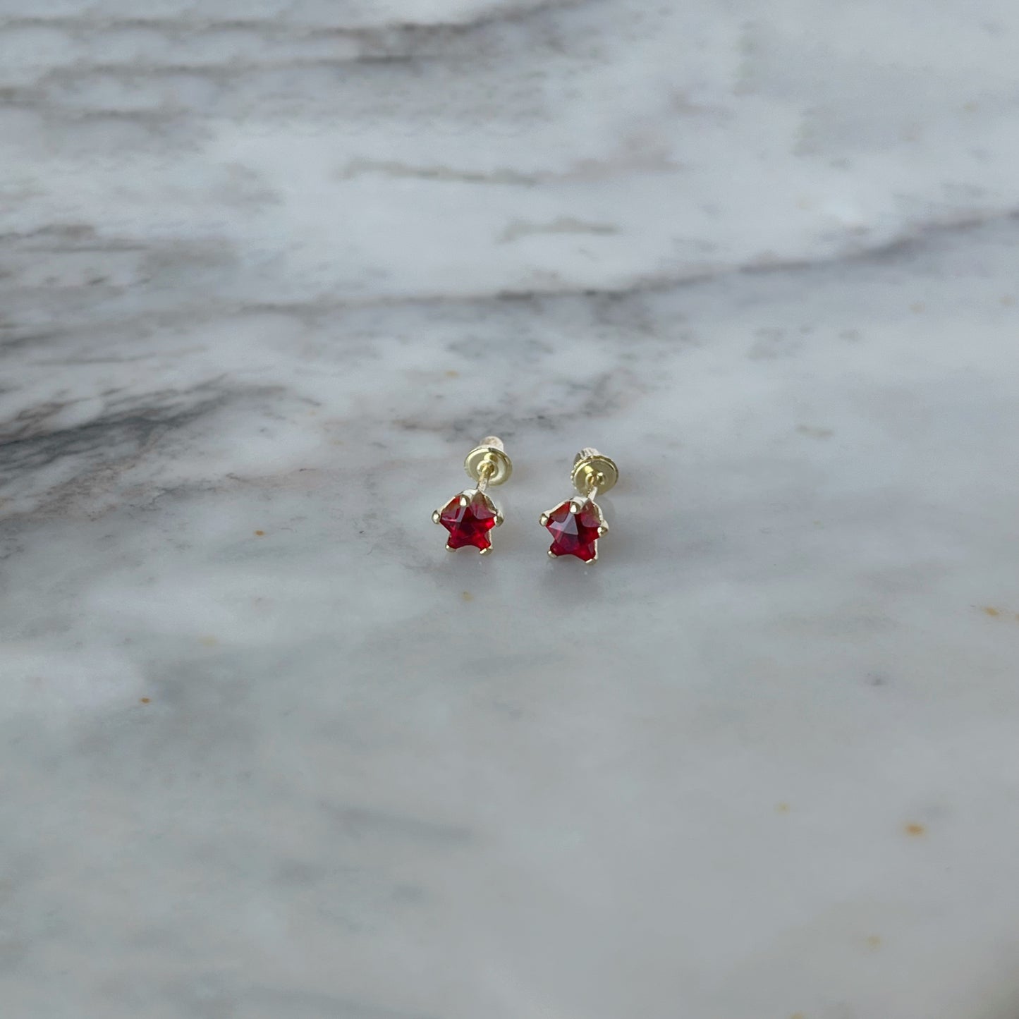 Aretes en oro amarillo 14K con estrella de circonita roja con tope rosca