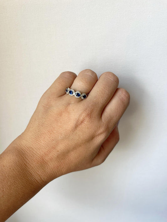 Anillo en oro blanco 14k con zafiros ovalados y halo de diamantes 0.35ctw