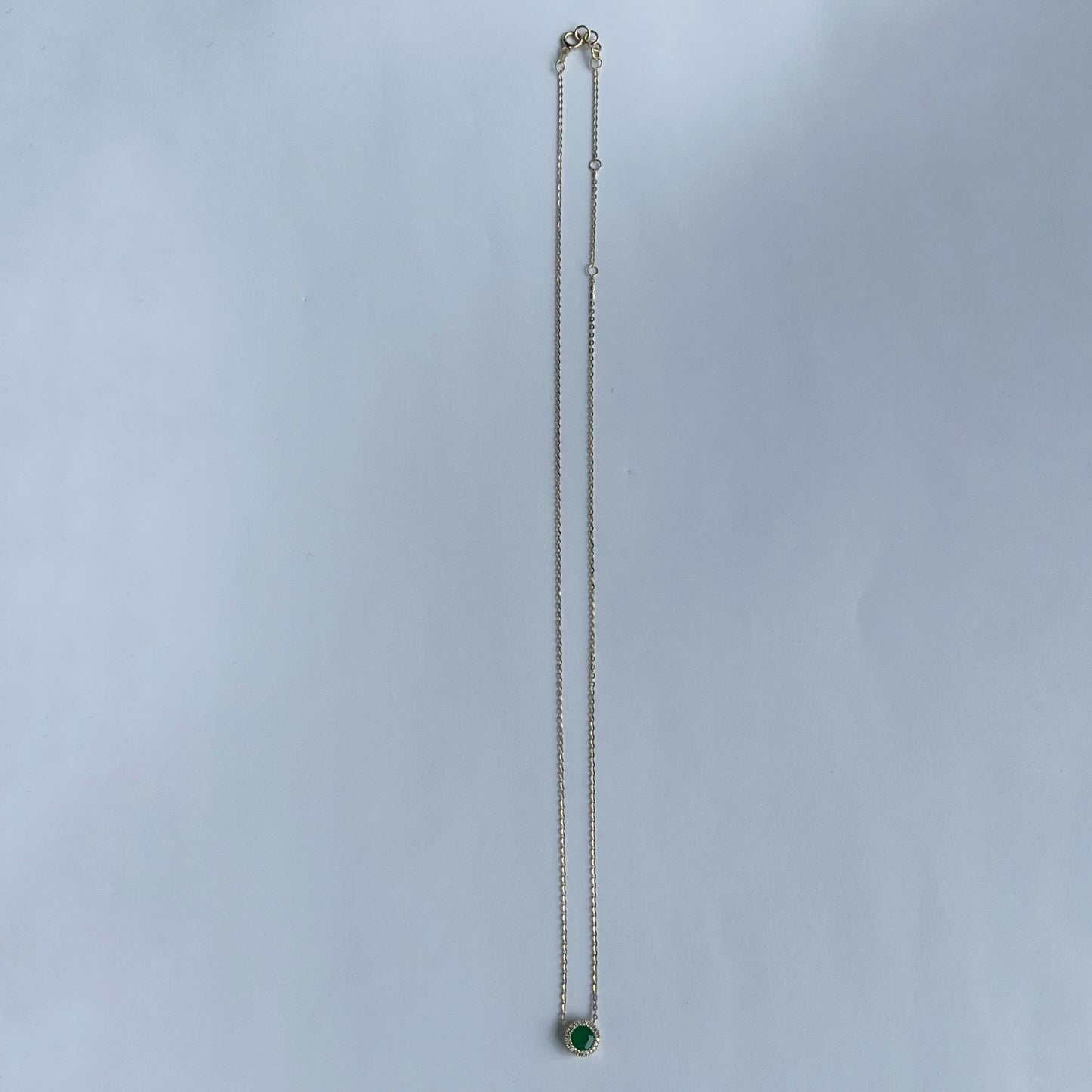 Collar en oro amarillo 14k con esmeralda redonda y halo de diamantes 0.06ctw