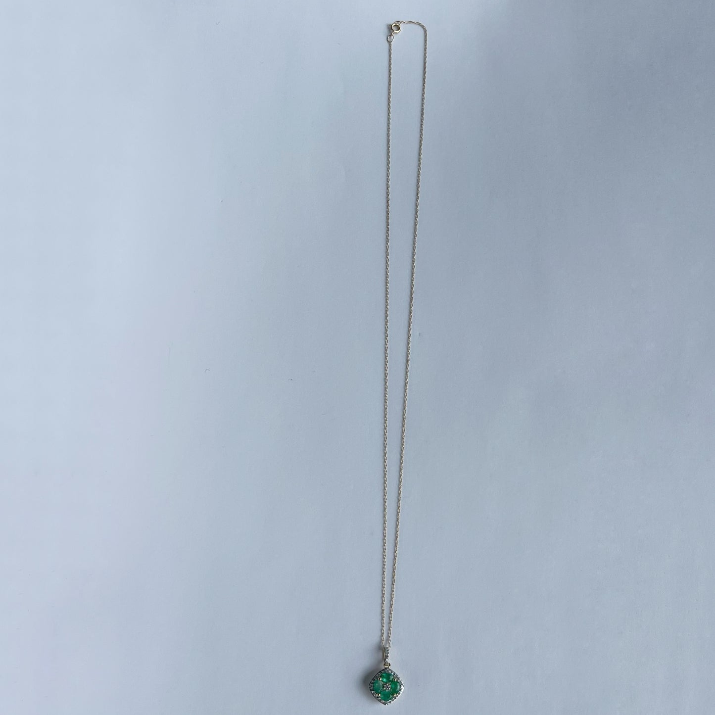 Collar en oro amarillo 14k con dije de esmeraldas en forma de flor y borde de diamantes 0.15ctw