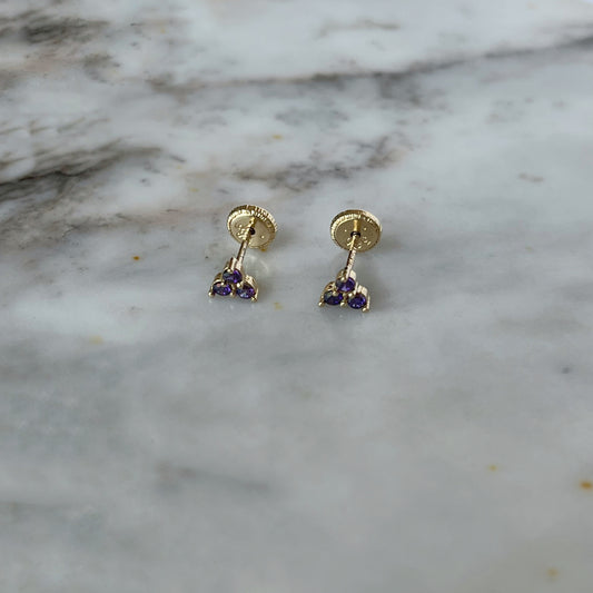 Aretes tres circonitas de color morado en oro amarillo de 14k con tope rosca