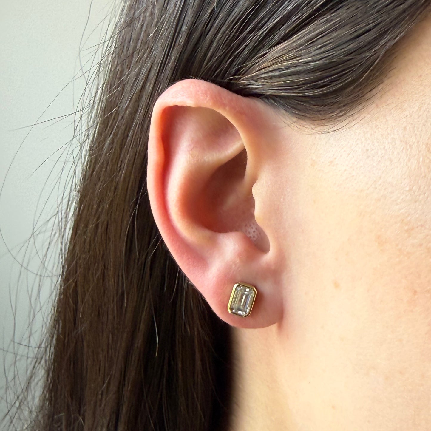 Aretes stud en plata con baño de oro con moissanita corte esmeralda biselada