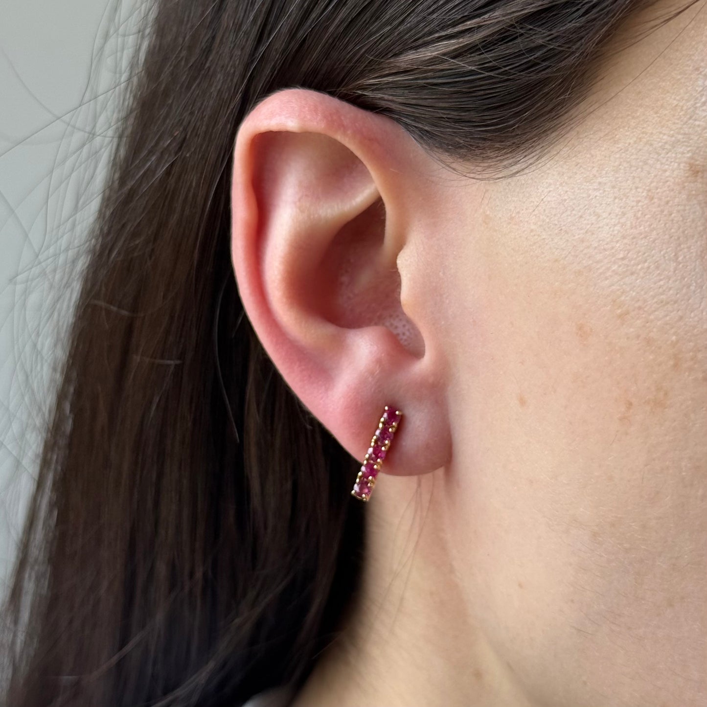 Aretes de plata con baño de oro y rubíes redondos en fila