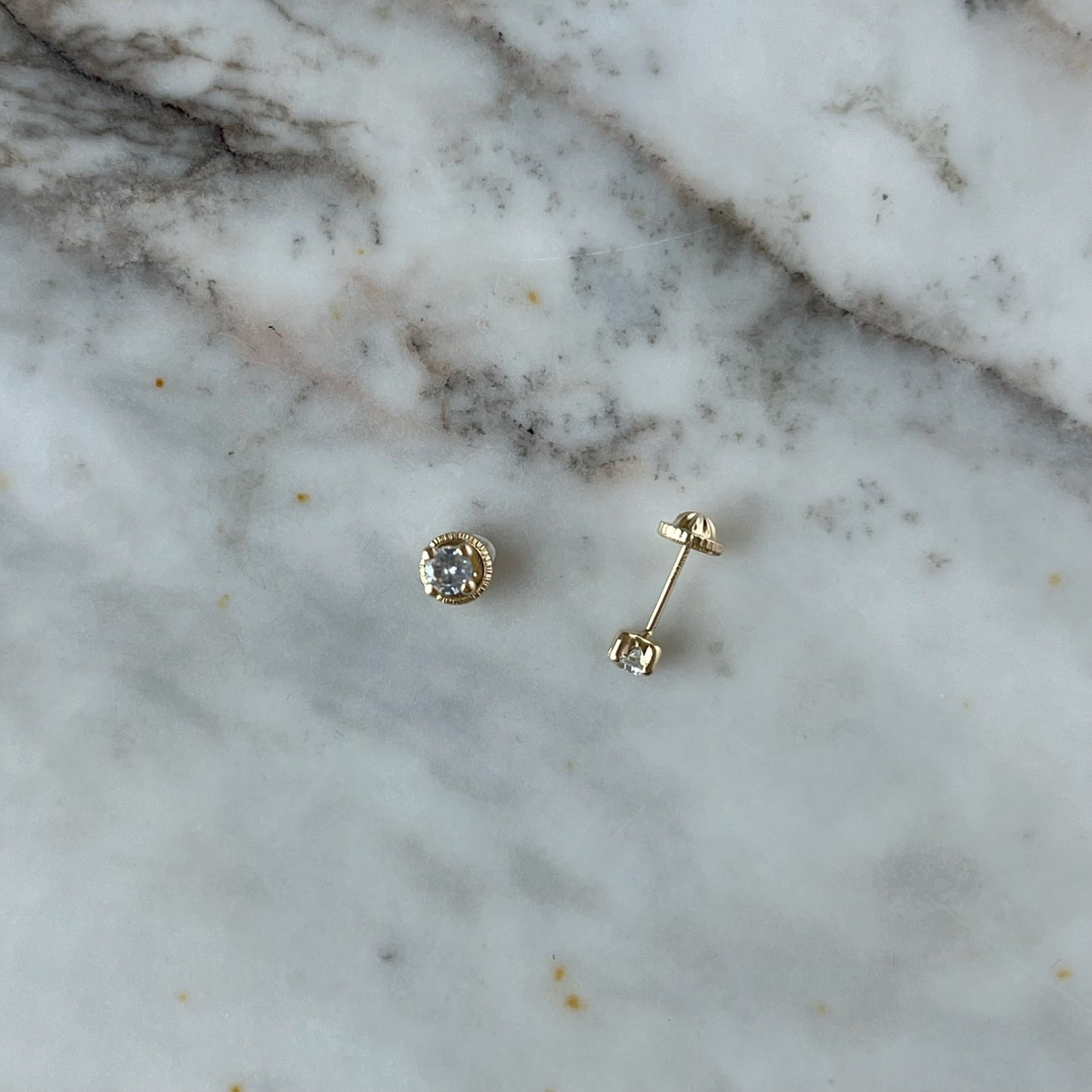 Aretes en oro amarillo 14K con circonita redonda blanca con cuatro agarres con tope rosca