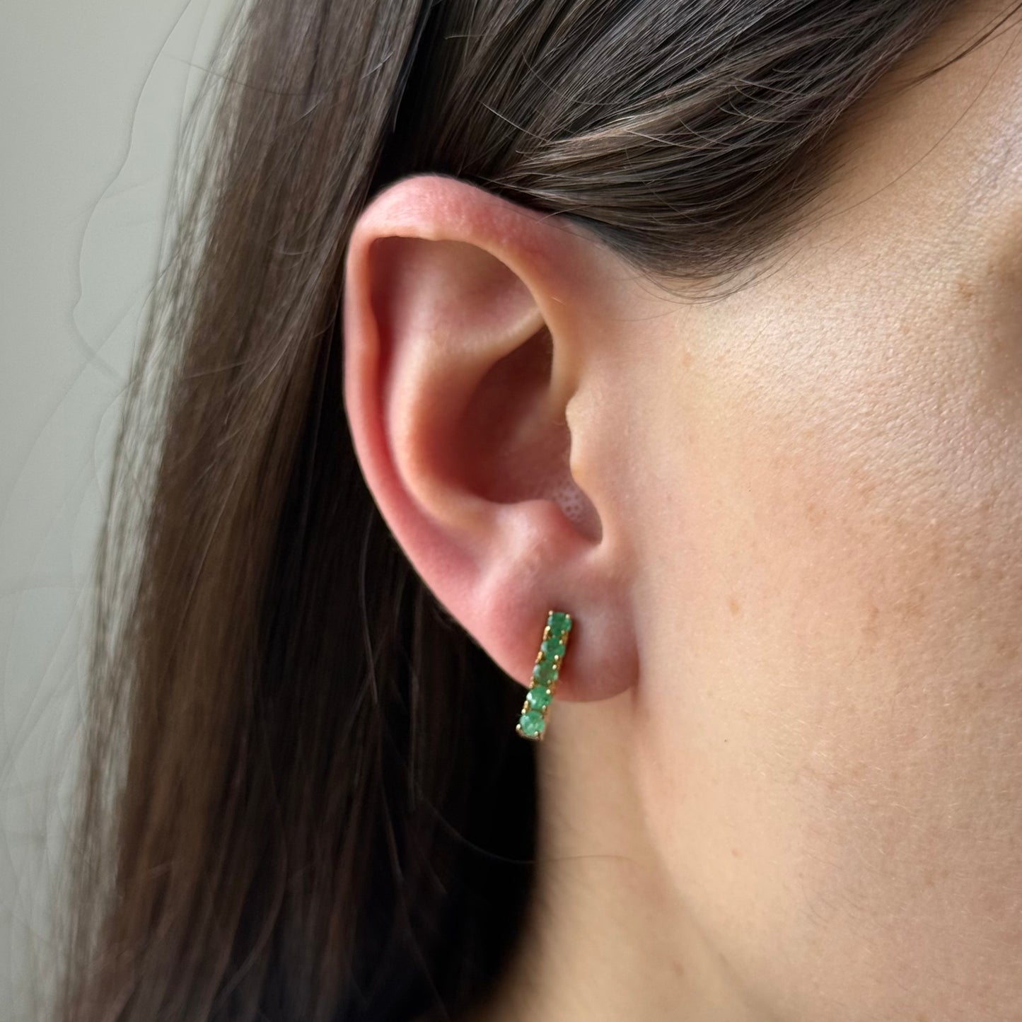 Aretes de plata con baño de oro y esmeraldas redondas en fila