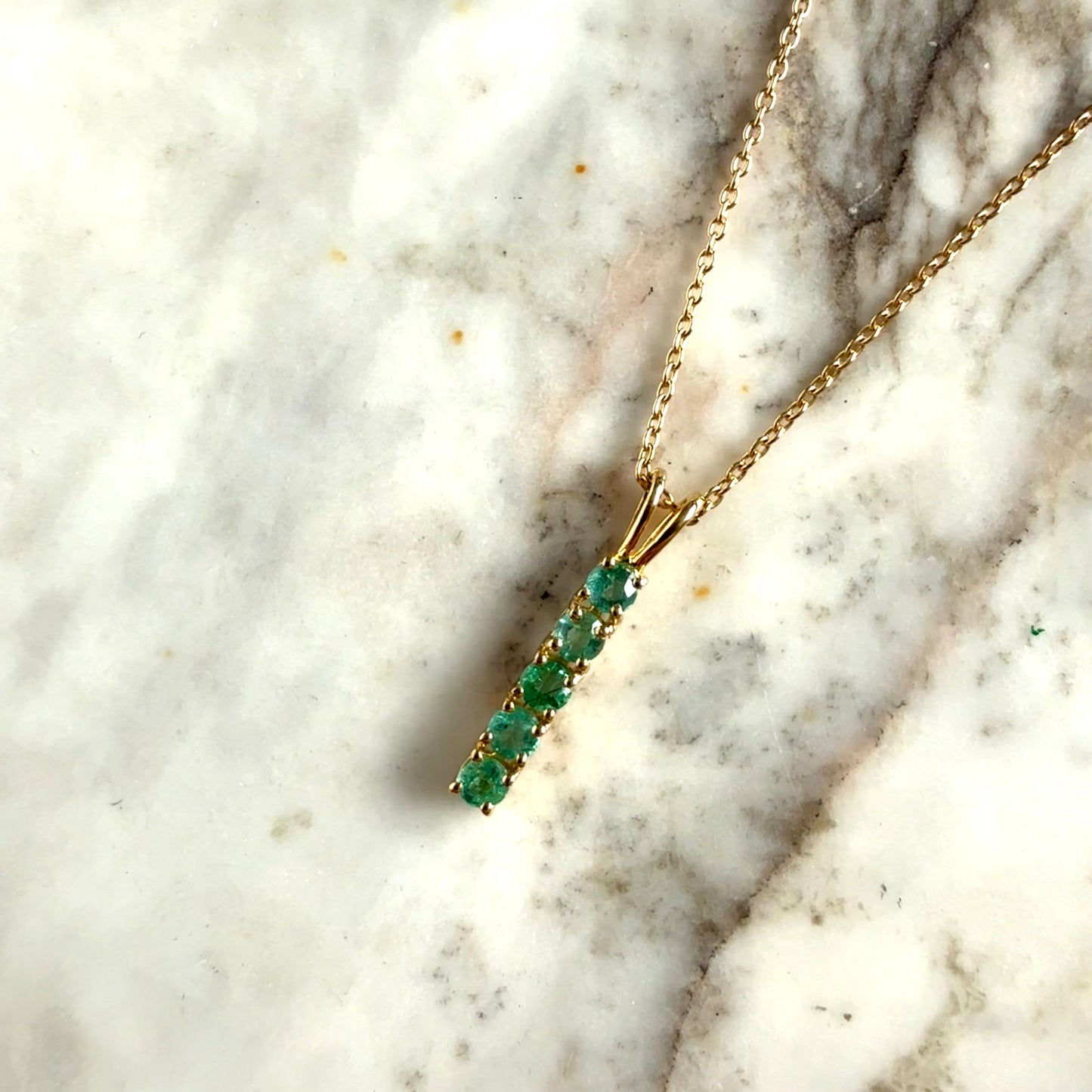 Collar de plata con baño de oro amarillo y esmeraldas redondas en fila