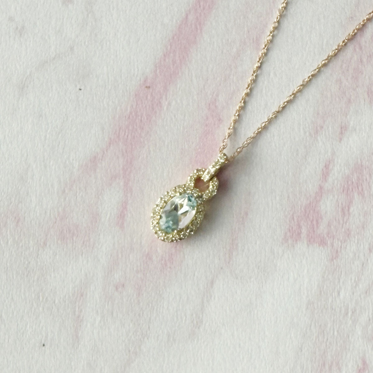 Collar en oro amarillo 10k con aguamarina ovalada con pasacadena y halo de diamantes 0.18ctw
