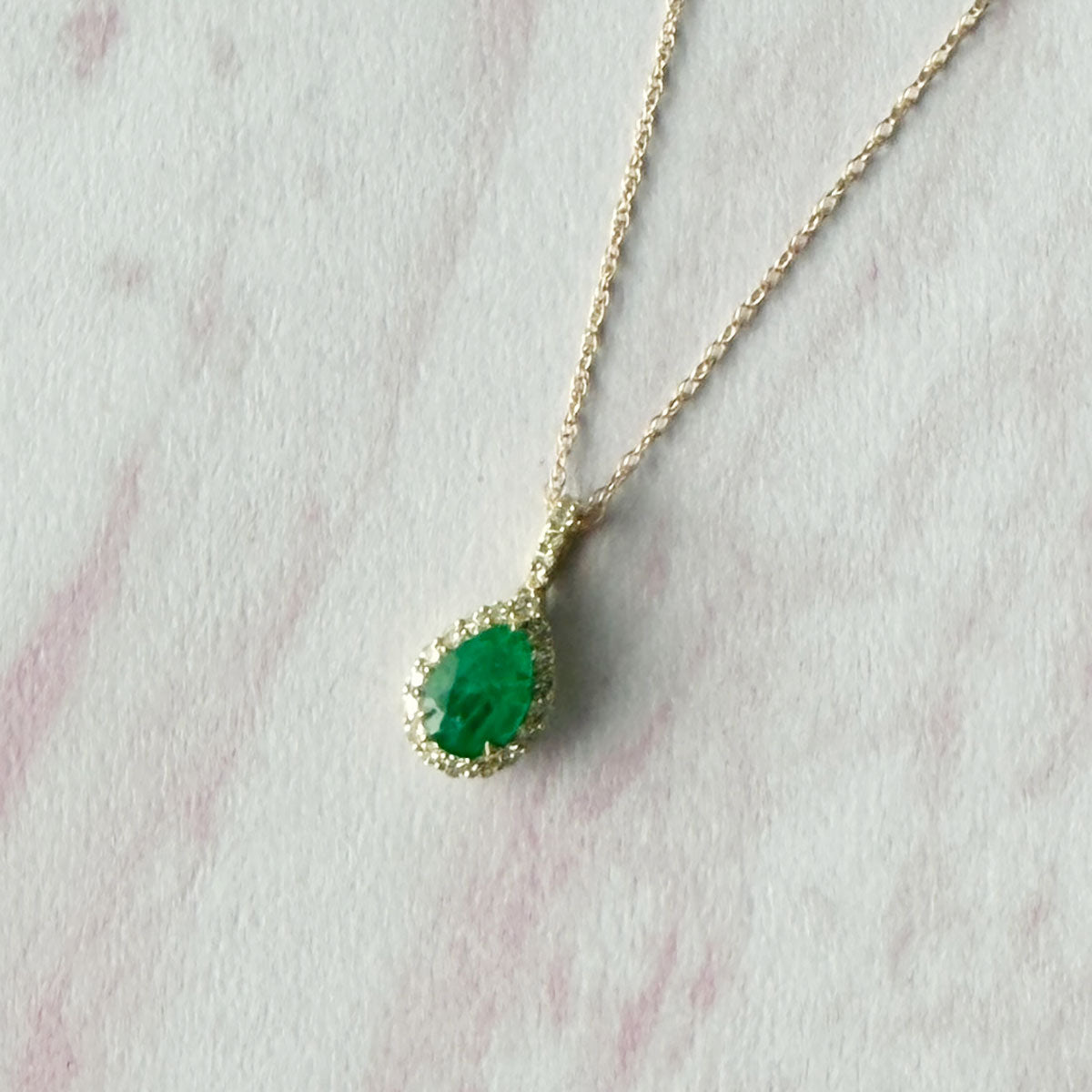 Collar en oro amarillo 10k con esmeralda corte pera 0.50ct con pasacadena y halo de diamantes 0.13ctw