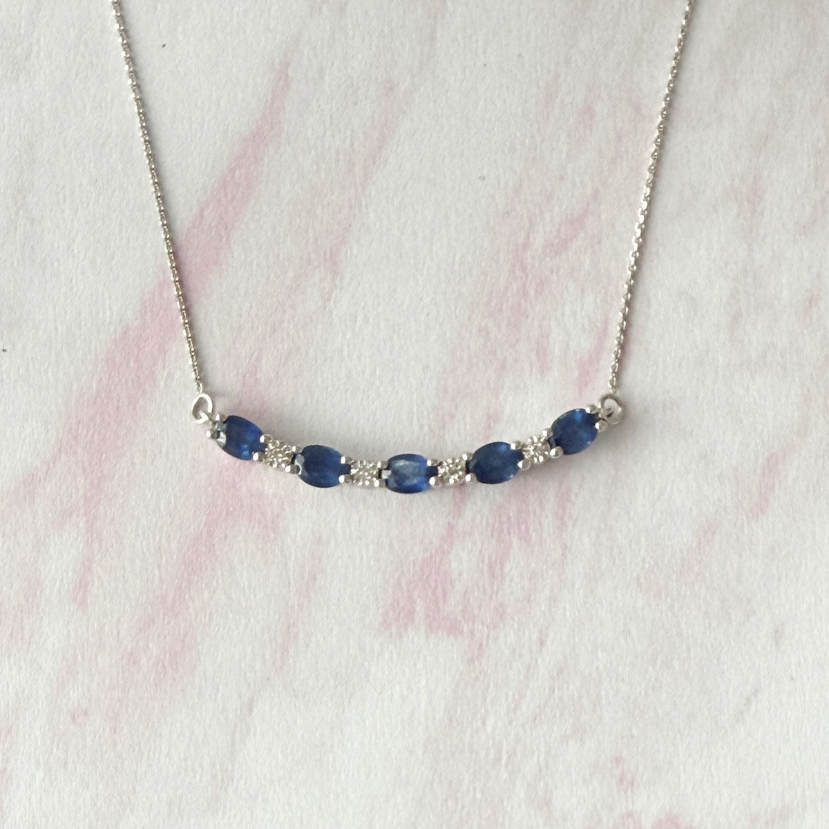 Collar en oro blanco 10k con curva de zafiros y diamantes