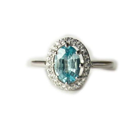 Anillo de plata con topacio azul ovalado y halo de circones