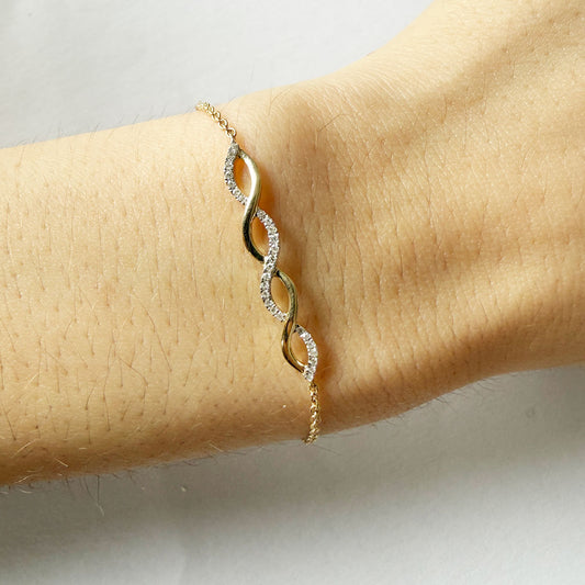 Pulsera en oro amarillo 10k con dije central de curvas con diamantes 0.09ctw